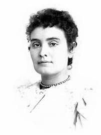 schwarzweisse Portraitaufnahme von Anne Sullivan. Sie trägt ein helles Kleid und eine schlichte Perlen- oder Schmuckkette. Ihr Gesichtsausdruck ist ernst, aber ruhig und würdevoll.