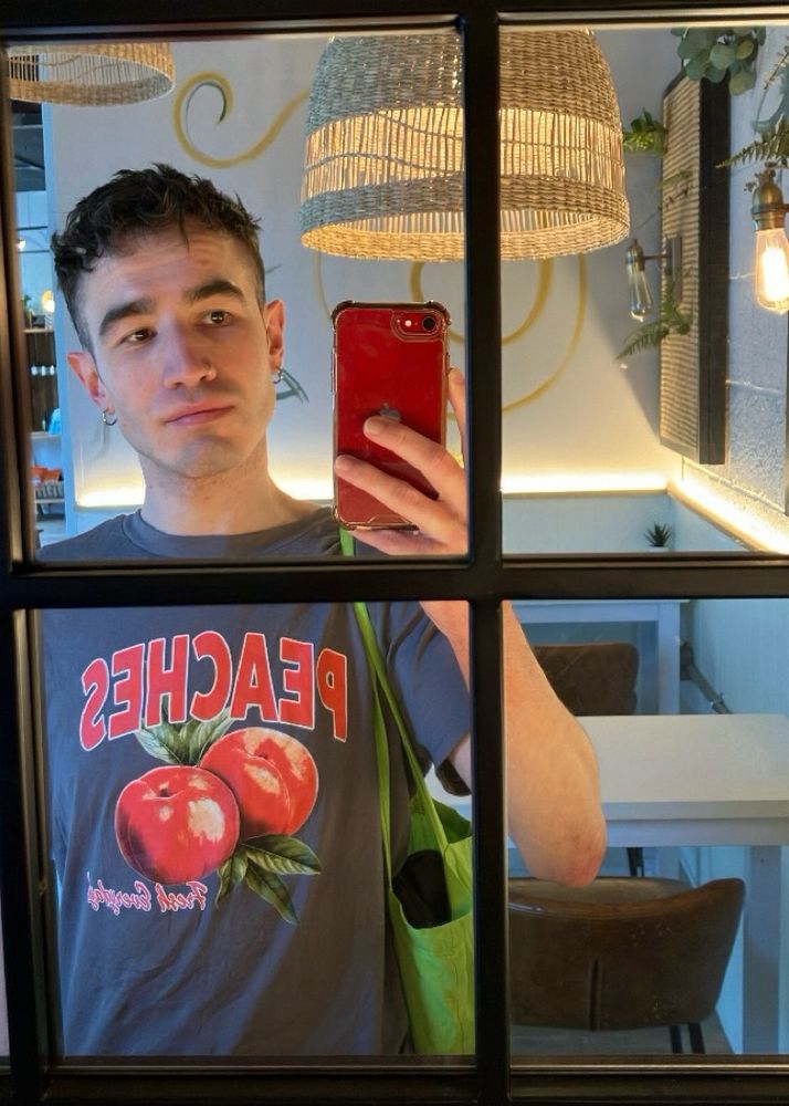 mirror selfie in a cafe, i'm wearing a tee with peaches on it