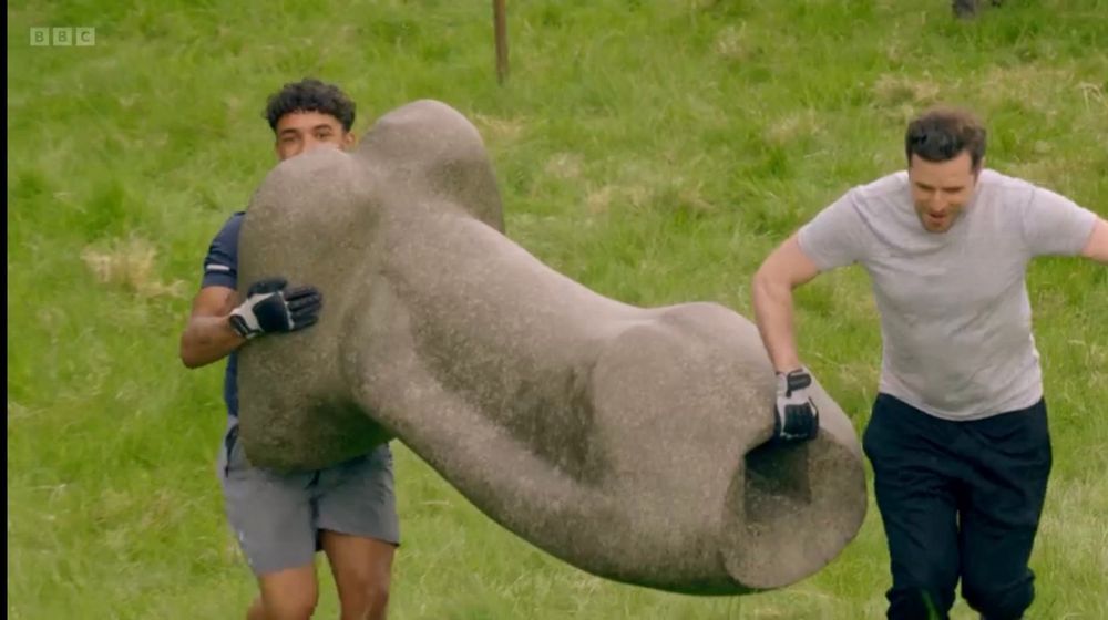 Freddie and Alexander carrying a stone that looks like a really big willy 