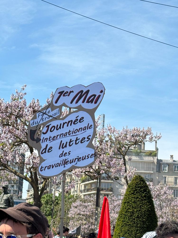Une pancarte journée internationale de luttes des travailleurs.euses