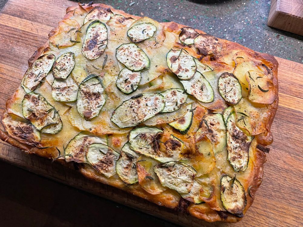 Finished focaccia on a cutting board. 