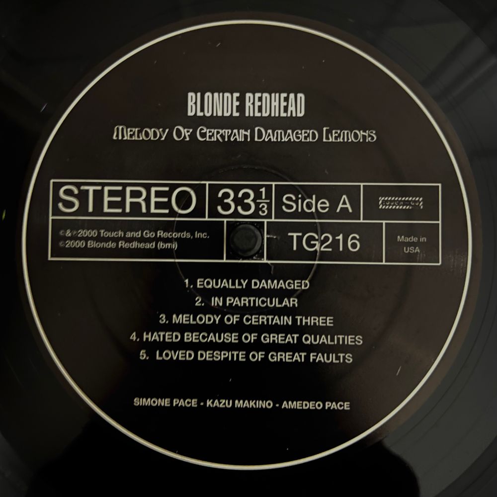Black label on a vinyl record with album and song info in white letters.