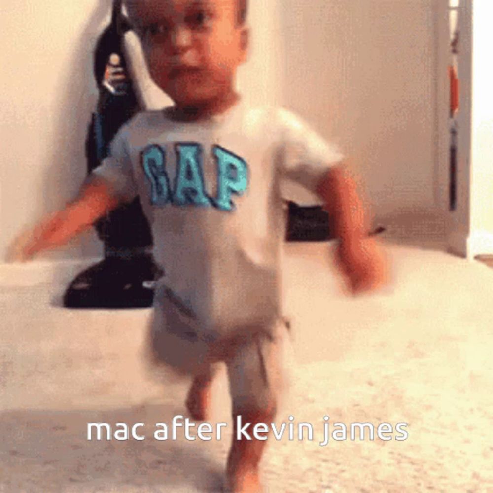 a baby wearing a gap shirt is running on the floor