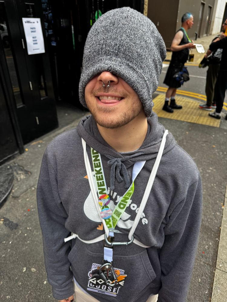 @musky.pet with his beanie pulled down over his eyes, tongue out. 