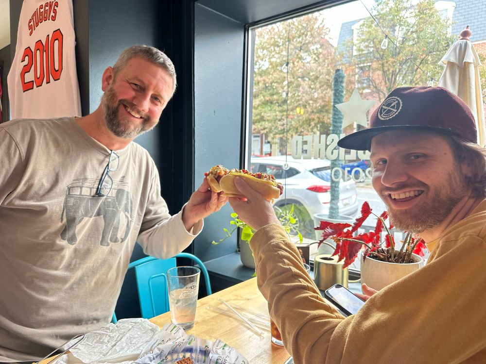 Two hotdog chatters cheersing some dogs 