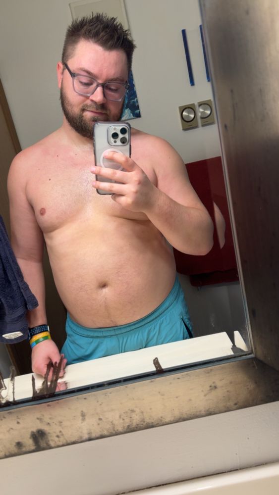 Me standing in the mirror sweaty with teal shorts on 
