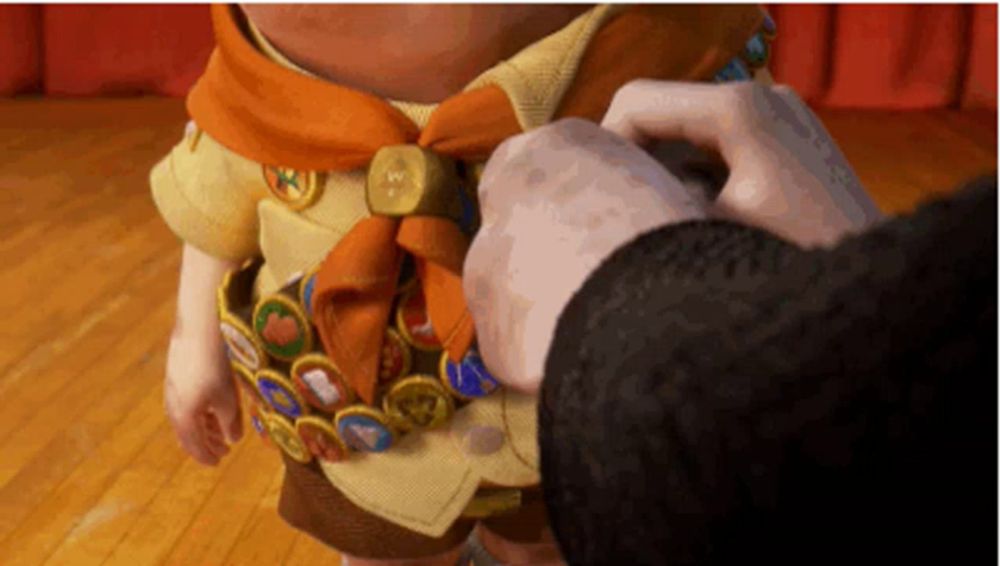 a person is putting a badge on a boy scout uniform