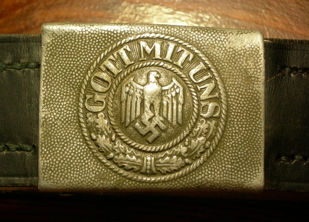 WWII Wehrmacht belt buckle. Centered is an eagle perched on a swastika. Around the top edge of the circular logo is "Gott Mit Uns" (God with us)