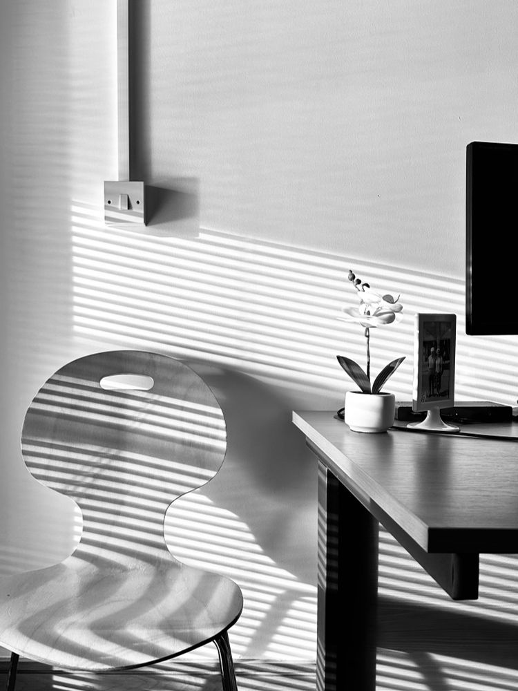 An office with sun streaming through Venetian blinds. 