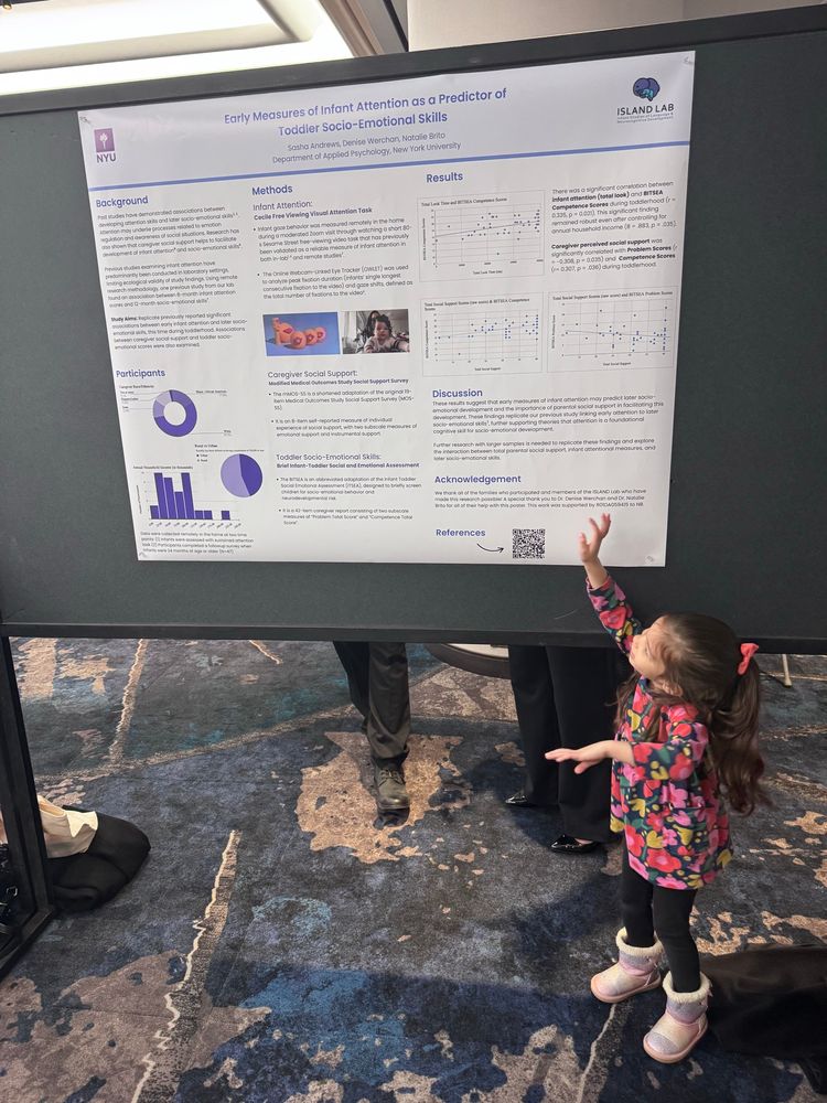Toddler next to a science conference poster 