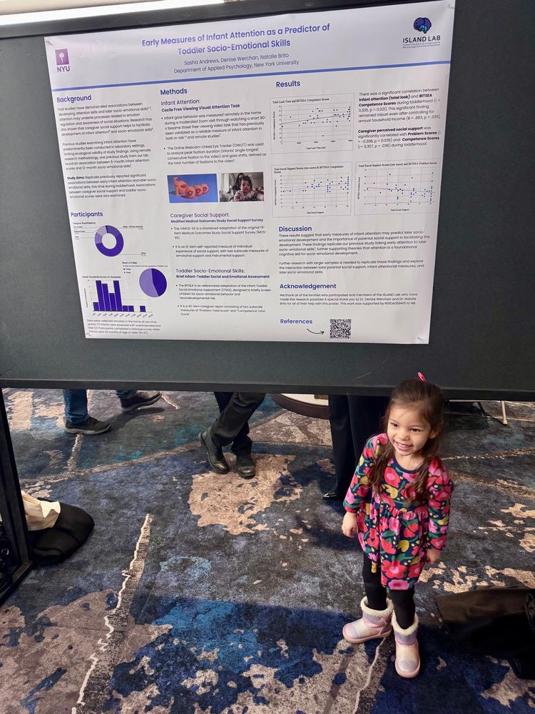 Toddler next to a science conference poster 