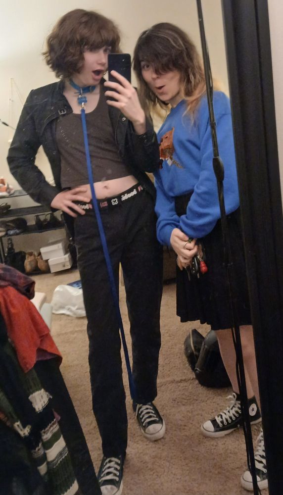 sky and basil both going :0 but this time its a mirror selfie. skys wearing her collar, a blue leash, a grey crop top, black pants, black converse and a belt that says "I <3 boobies" basil is wearing a blue sweater and a black skirt