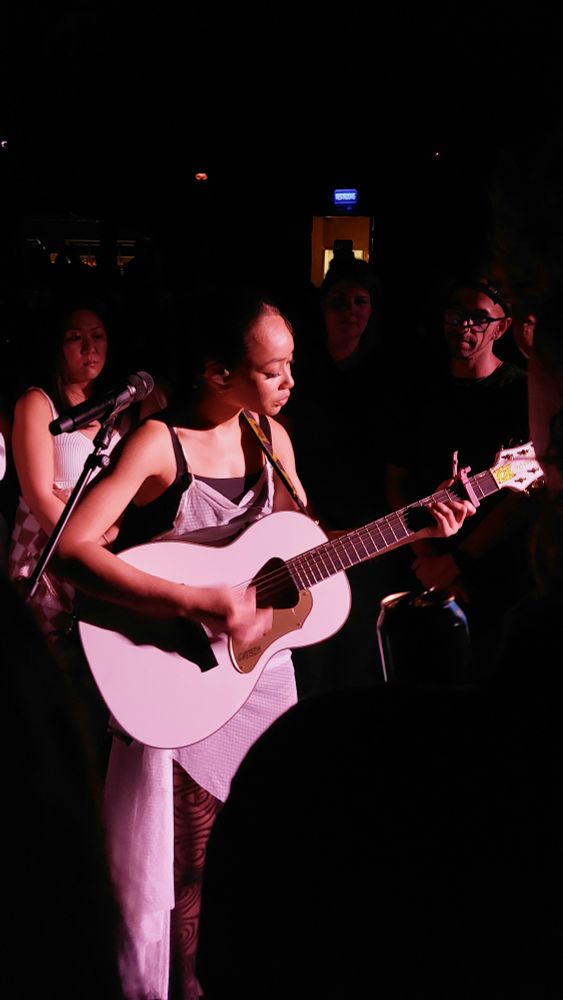 Close up of Griff playing accoustic guitar