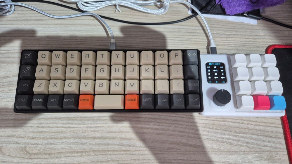 Foto dois teclados. O YMDK Air40 e um ErgoHaven M4cr0Pad.