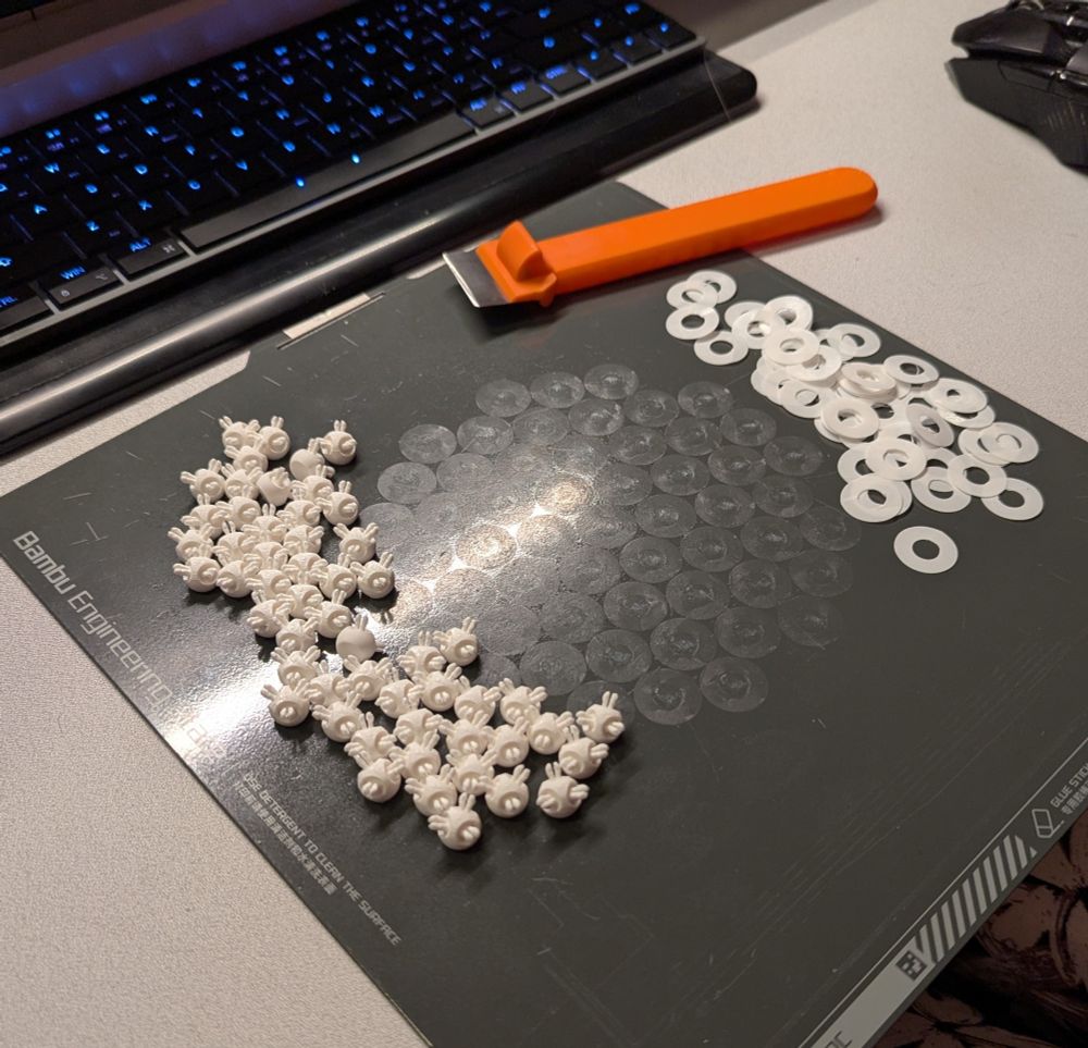 a 3D printing plate, with small white spheres with three pegs having been detached and cleaned up