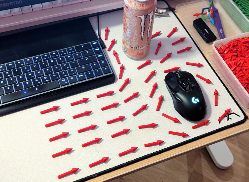 a bunch of red physical arrows on Freya's desk arranged like a fluid simulation vector field