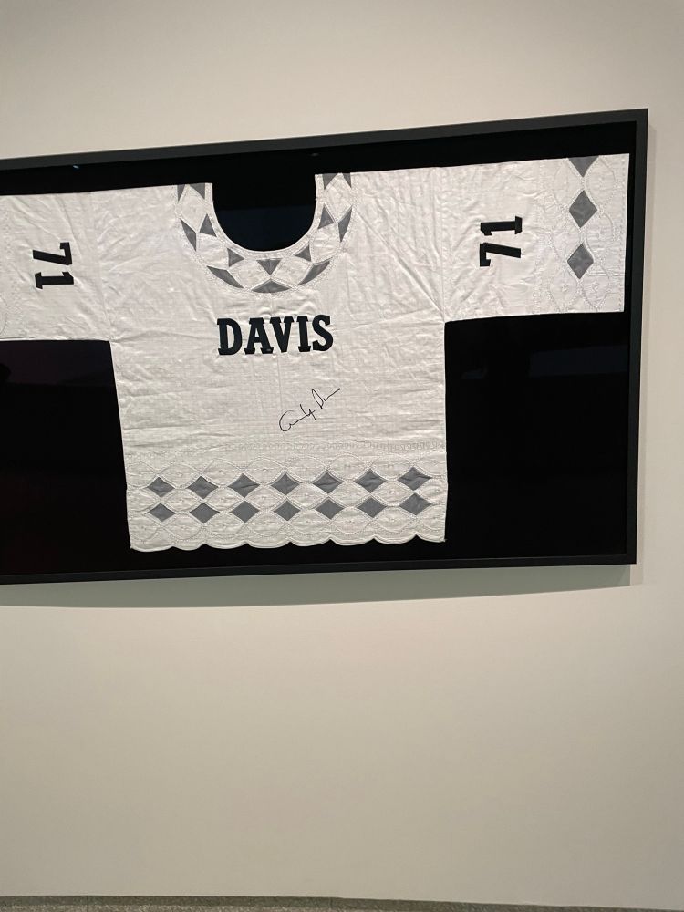 Signed Dashiki-style jersey with the name “Davis” on it hung up like an athlete’s jersey.