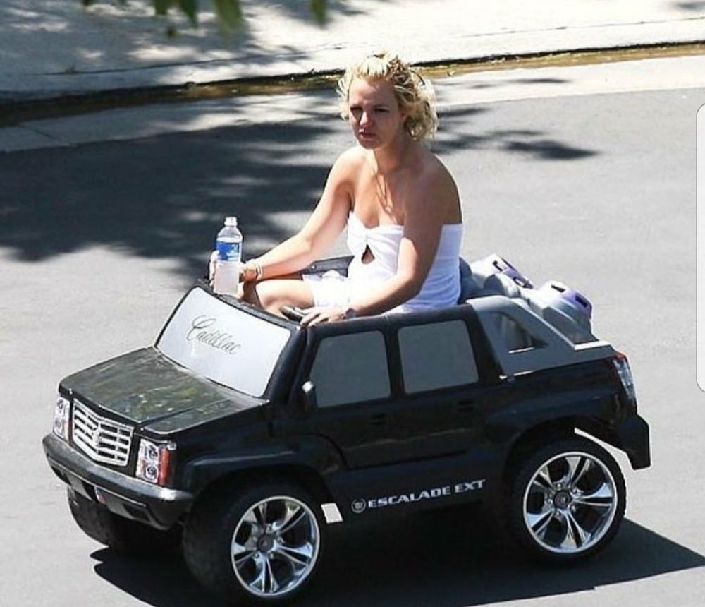Britney Spears sits atop a mini Escalade, she has a bottle of water in one hand, her hair is charmingly disheveled and she looks contemplative.

(seriously guys this is the meme that keeps on giving i have used it sooo many times, truly an iconic moment) 