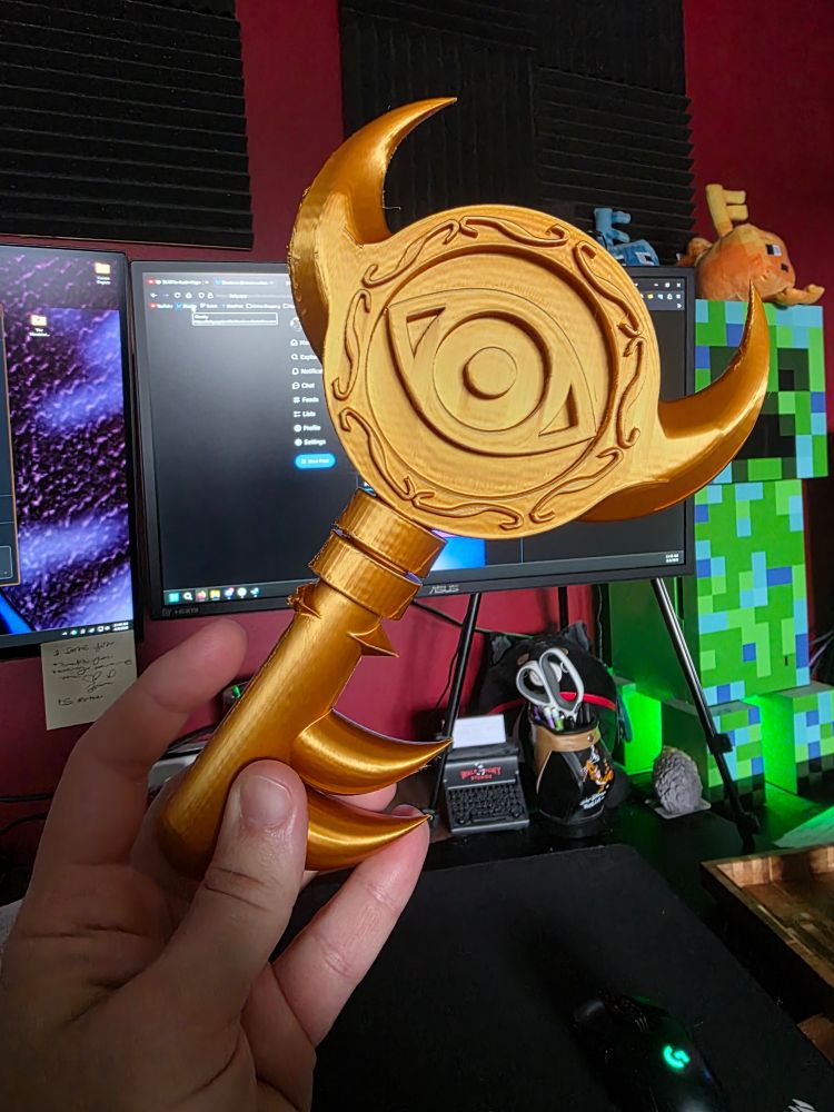 3d print of the boss key from The Legend of Zelda: Windwaker. There is a small defect in the print being pointed to