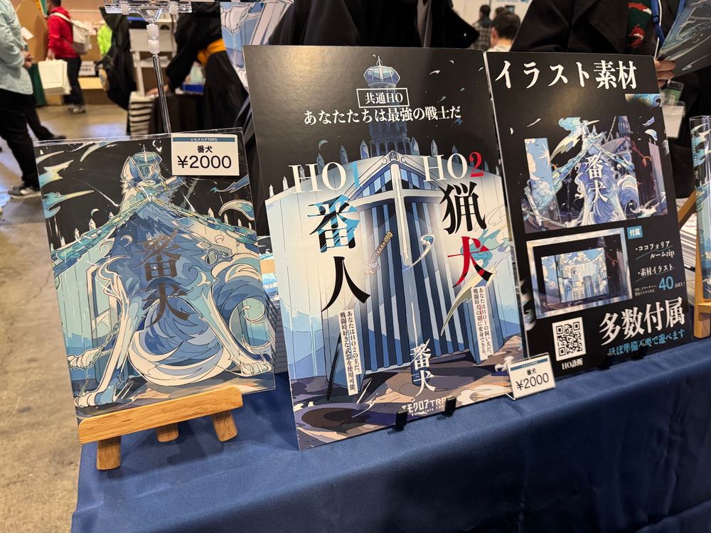 picture of booth selling 「番犬」, promo posters and people behind the booth 