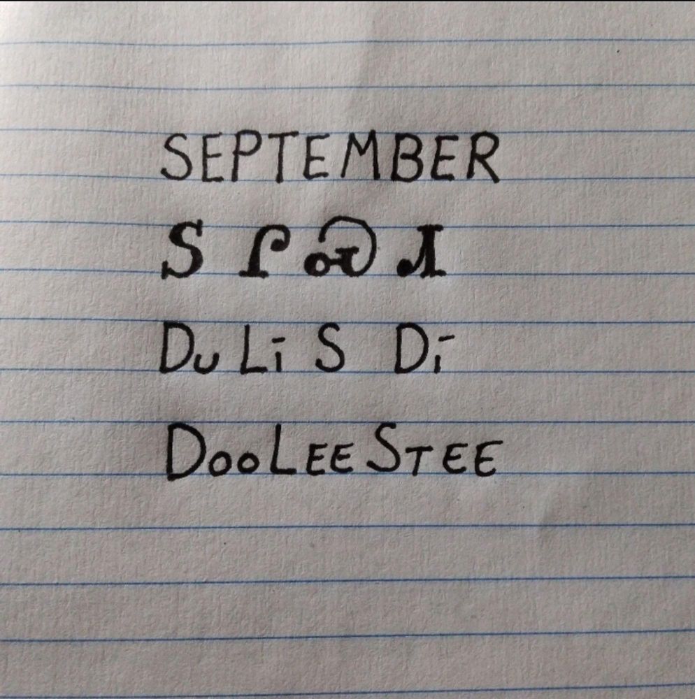 Image is line paper with writing showing an English word followed by how it is written in the Cherokee language followed by how it is spelled and pronounced. The word is September and pronounced dooleestee
