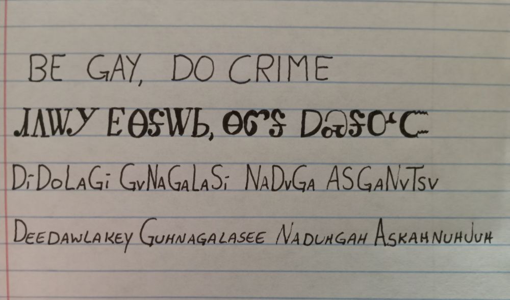 Image is line paper with writing showing an English word followed by how it is written in the Cherokee language followed by how it is spelled and pronounced. The words are be gay, do crime and pronounced deedawlakey guhnagalasee nadugah askahnuhjuh