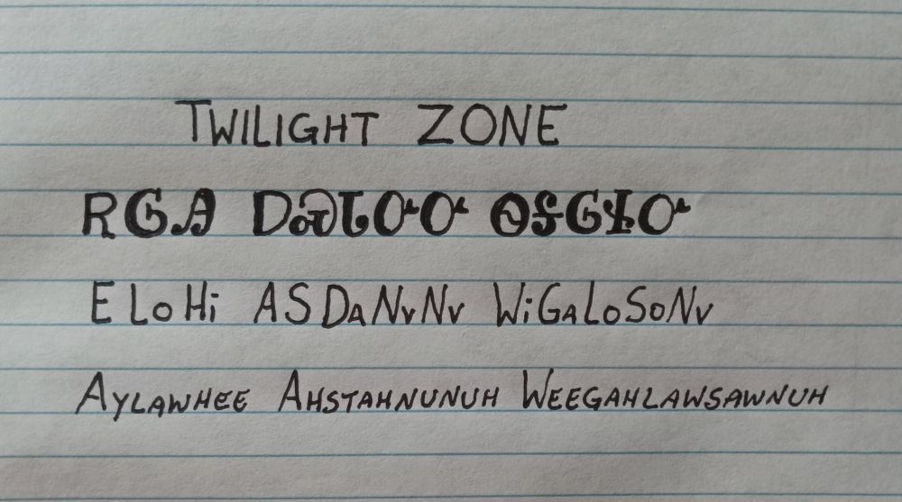 Image is line paper with writing showing an English word followed by how it is written in the Cherokee language followed by how it is spelled and pronounced. The words are twilight zone and pronounced aylawhee ahstahnunuh weegahlawsawnuh