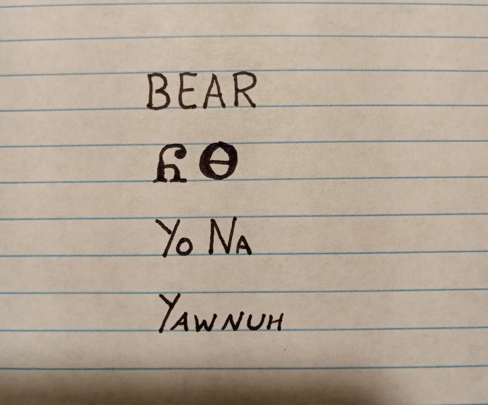 Image is line paper with writing showing an English word followed by how it is written in the Cherokee language followed by how it is spelled and pronounced. The word is bear and pronounced yawnuh