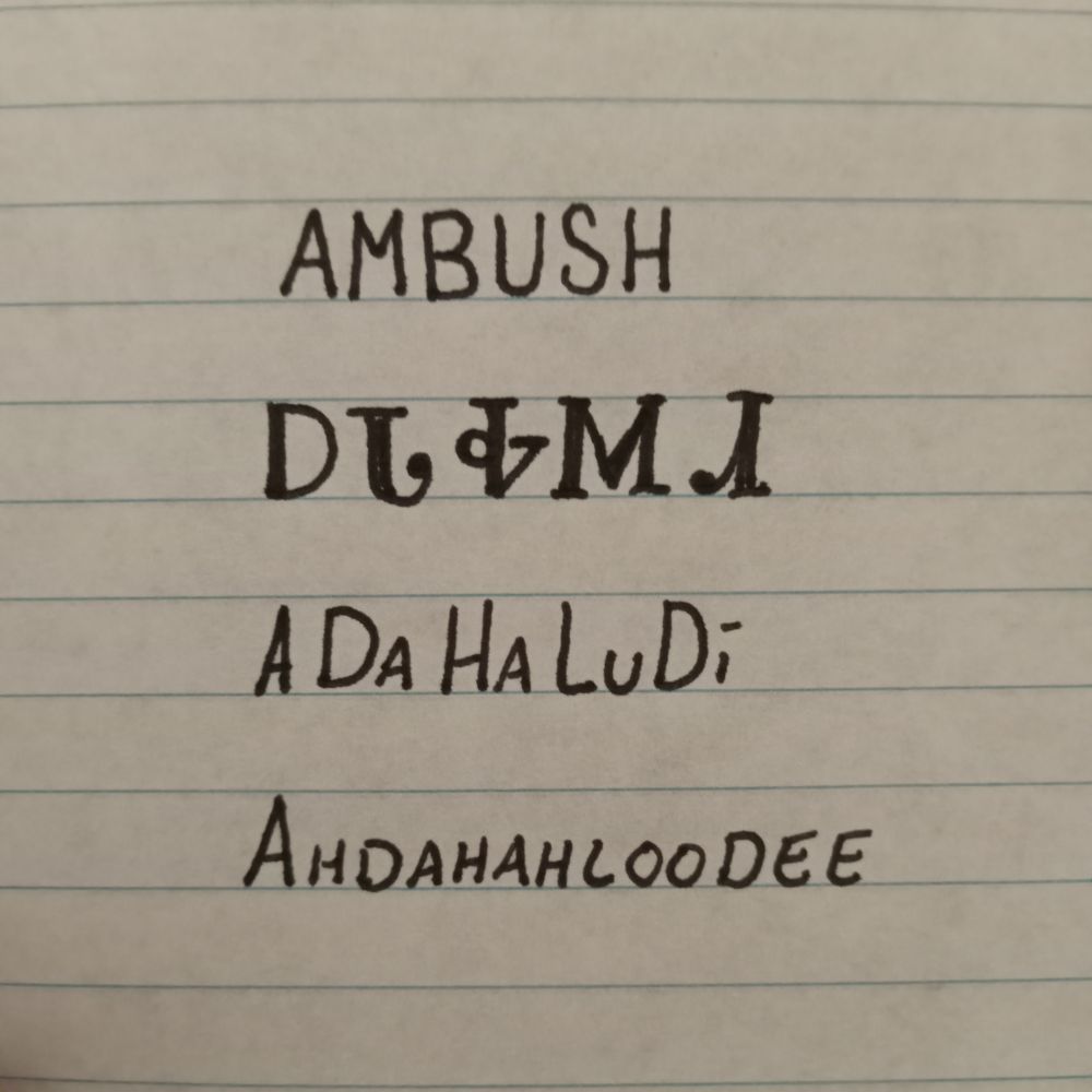 Image is line paper with writing showing an English word followed by how it is written in the Cherokee language followed by how it is spelled and pronounced. The word is ambush and pronounced ahdahahloodee