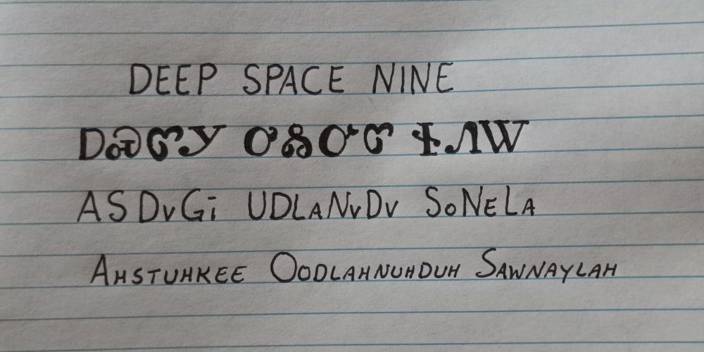 Image is line paper with writing showing an English word followed by how it is written in the Cherokee language followed by how it is spelled and pronounced. The words are deep space 9 and pronounced ahstuhkee oodlahnuhduh sawnaylah