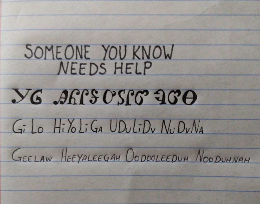 Image is line paper with writing showing an English word followed by how it is written in the Cherokee language followed by how it is spelled and pronounced. The words are someone you know needs help and pronounced geelaw heeyaleegah oodooleeduh nooduhyah