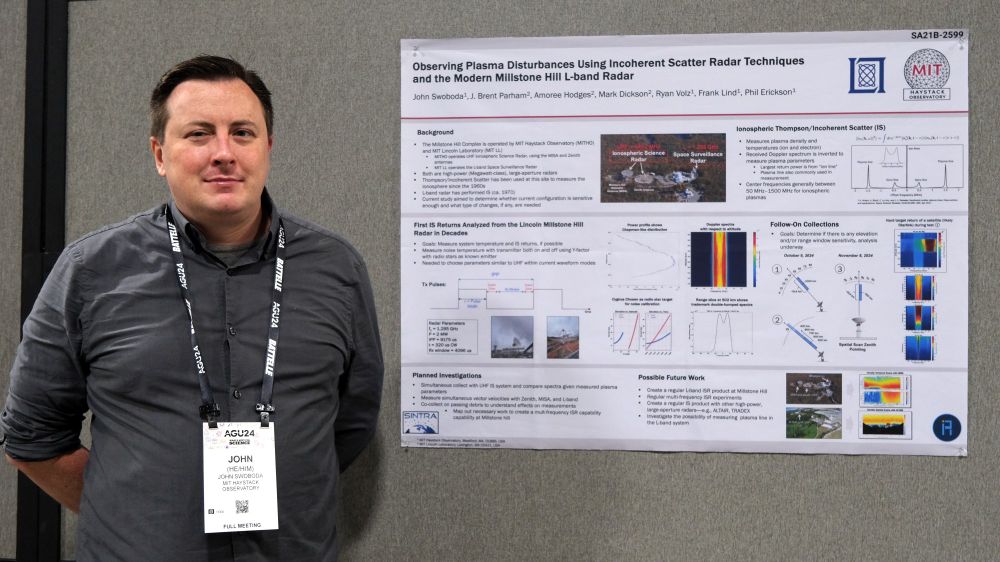 A man standing next to a scientific poster