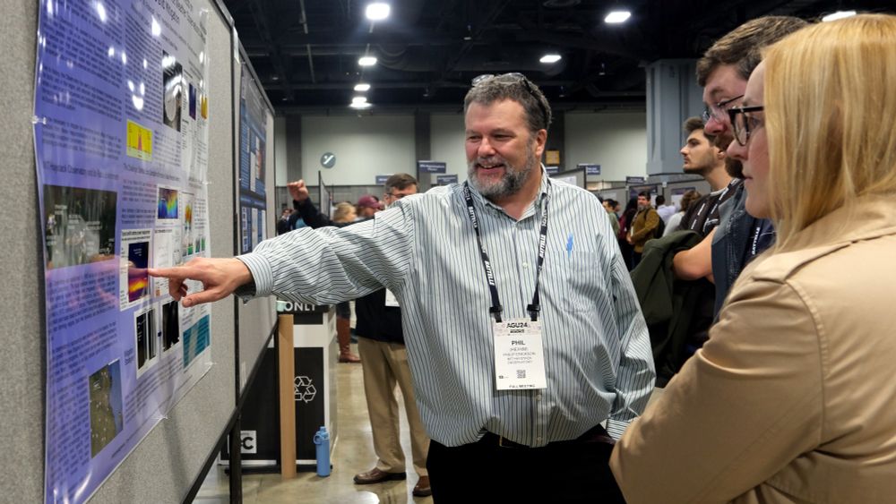 A man standing next to a scientific poster