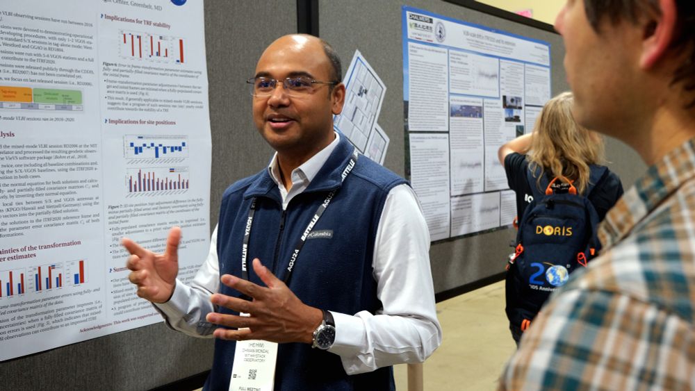 A man standing next to a scientific poster