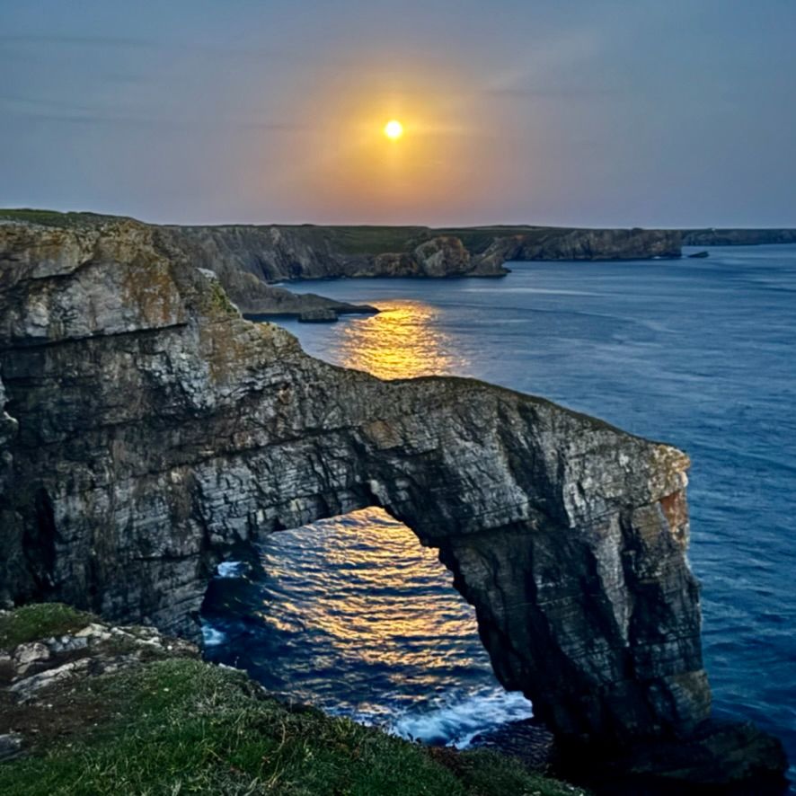 The Harvest Moon rising above the Green Bridge of Wales, Pembrokeshire, Wales, September 2024