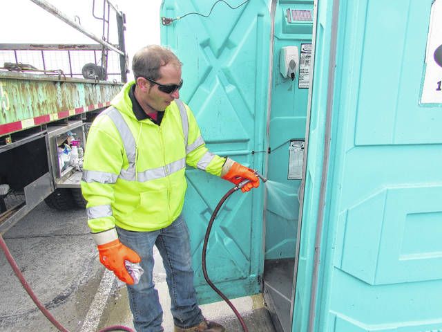 Man cleans portable toilet