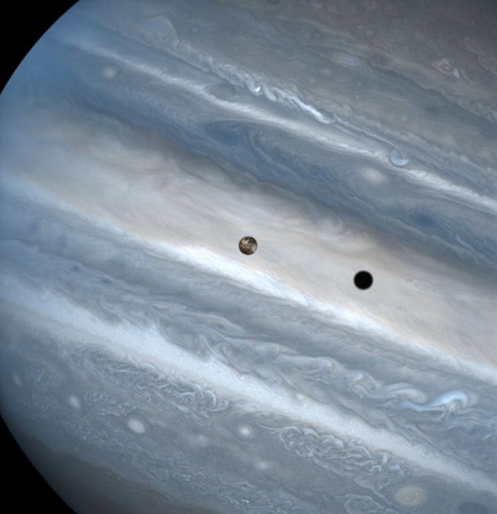 This Hubble image shows the moon Io passing above Jupiter's clouds. The black spot on the gas giant is Io's shadow.