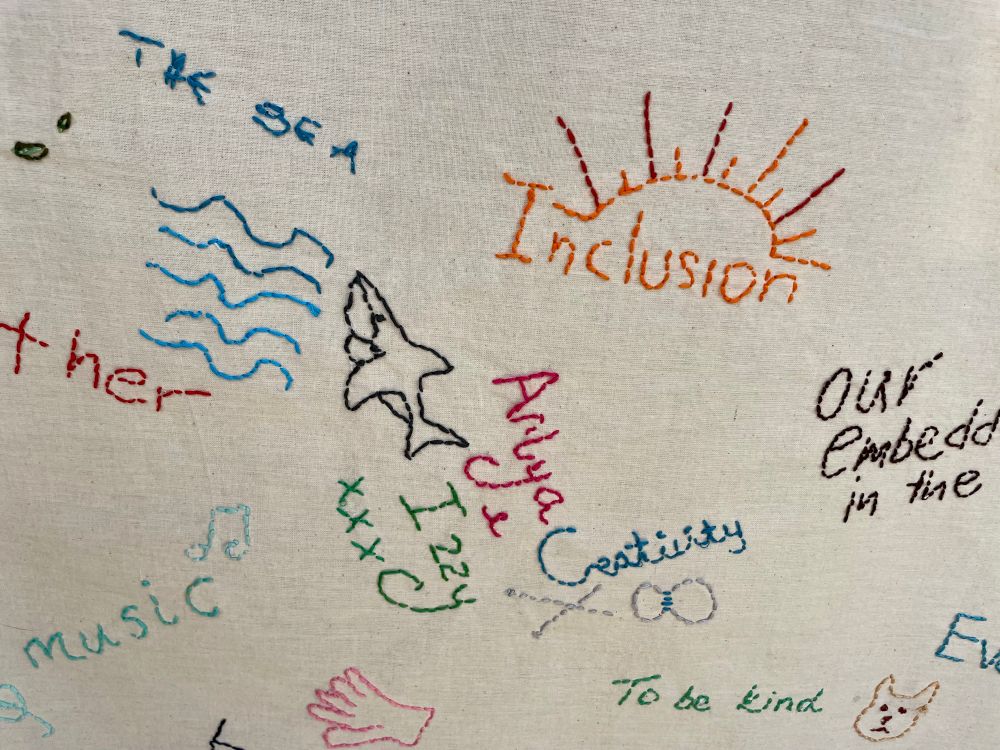 Colourful embroidered words on calico