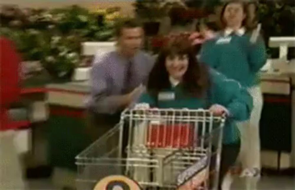 a woman pushing a shopping cart in a store .