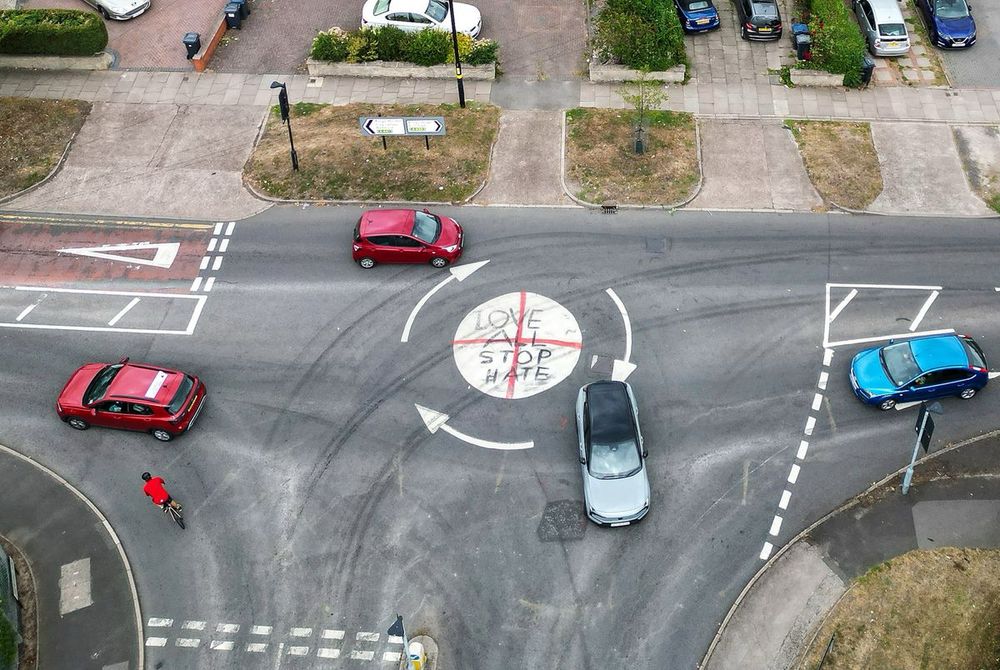 A Birmingham mini-roundabout has been vandalised with a 'Love All Stop Hate' graffiti message, painted over a St George's Cross that appeared during a flag debate.