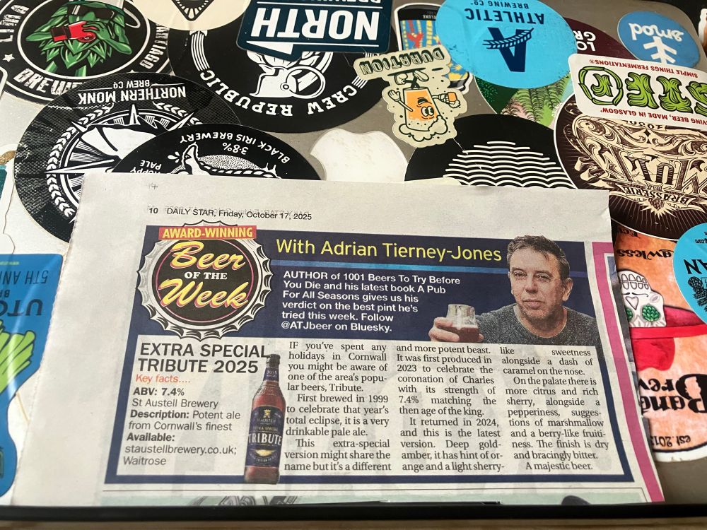 Cutting of beer of the week resting on a closed laptop