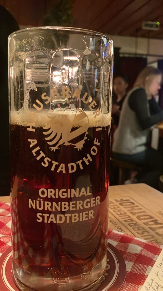 Close up of a glass of Rotbier resting on a wooden table with a red patterned napkin 