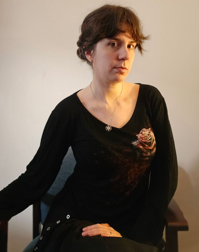 Jax sits while wearing all black except for a bloody white rose