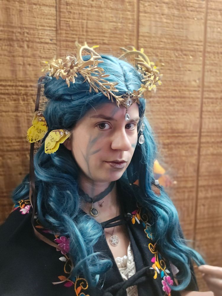 Jax in a green wig with a crown and butterflies