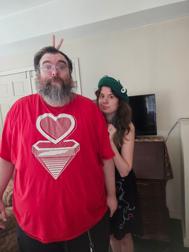 Jax stands behind her husband and gives him bunny ears