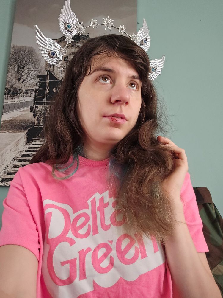 Jax in a Delta Green shirt and Ophanim headband