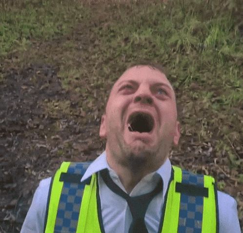 a man wearing a yellow vest and tie is making a face