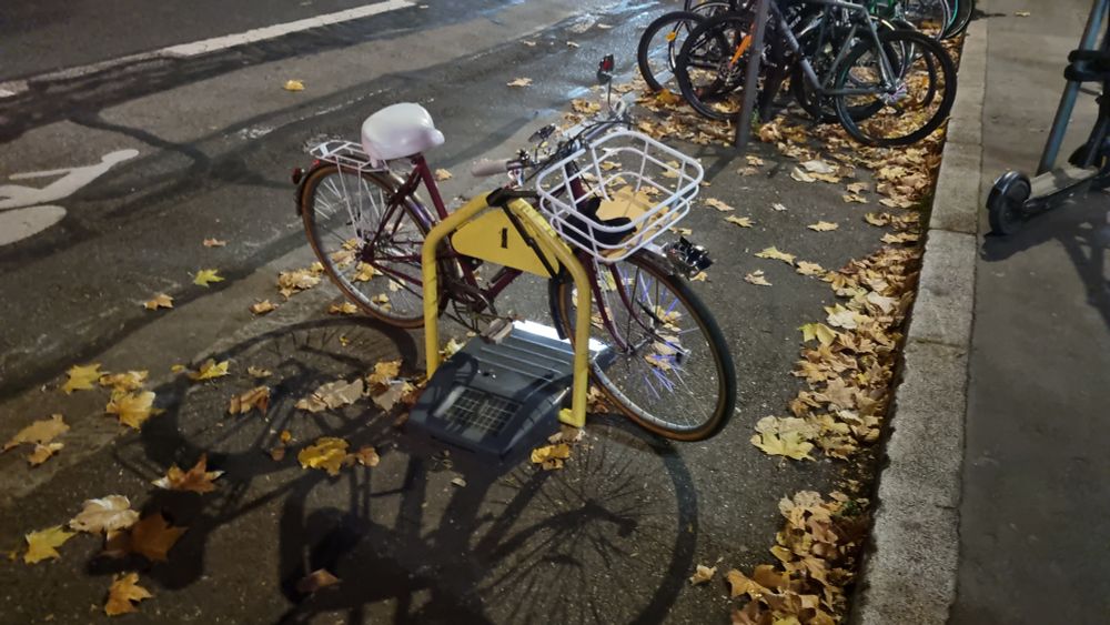 Un vélo attaché sur une borne d'autopartage.