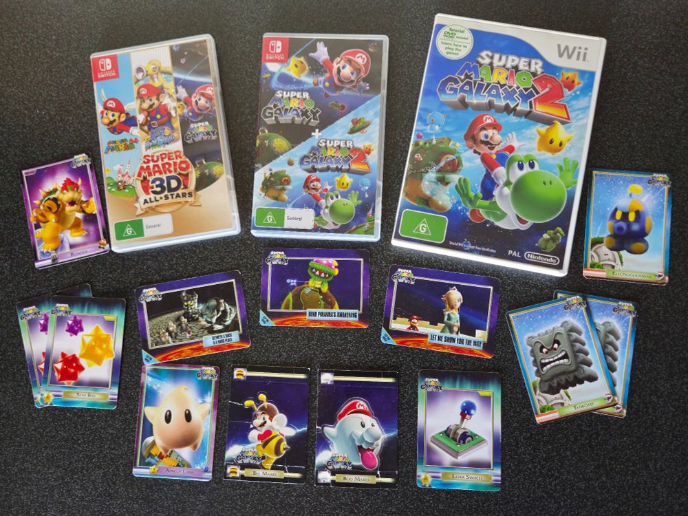 Copies of Super Mario 3D All-Stars, Super Mario Galaxy 2 on Wii and Super Mario Galaxy 1 + 2 on Switch, alongside a collection of Super Mario Galaxy trading cards