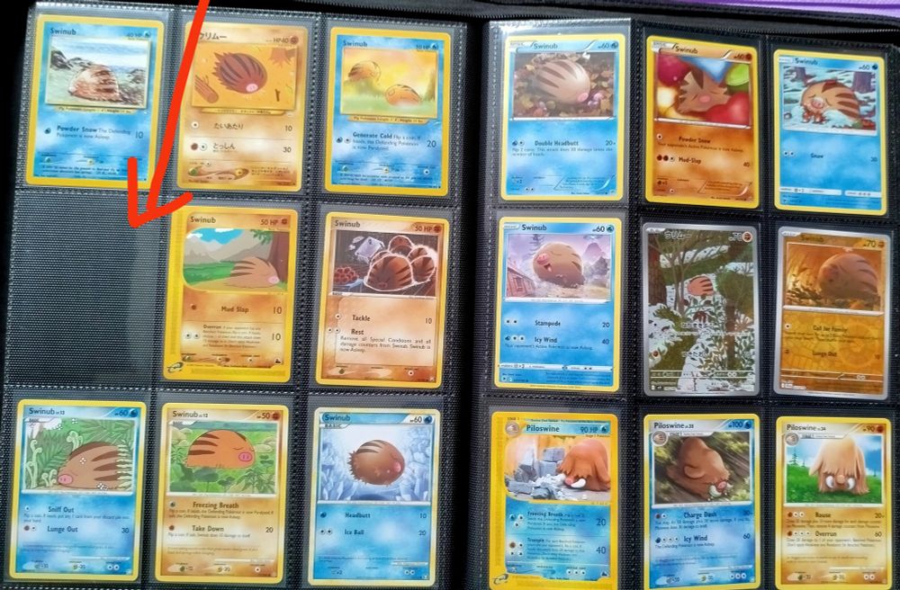 An open binder of swinub trading cards. One is missing.